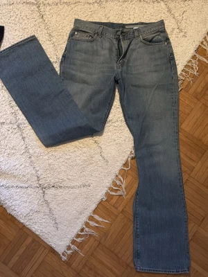 Blå raka jeans med klassisk passform - Säljer ett par Calvin Klein blå jeans med rak passform och klassisk femficksdesign. Jeansen har en ljusblå tvätt och är tillverkade i denim. Perfekta för dig som gillar en tidlös och enkel stil. De är perfekta för längre personer, eftersom benen är riktigt långa🥰🥰🥰
