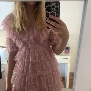 Rosa volangklänning i spets - Supersöt rosa kortklänning med flera lager volanger och spetsdetaljer. Sky dress, storlek M från By Malina. Nypris 2800kr. Använd två gånger, och det finns inga tecken på användning. 