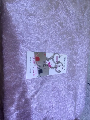 Bästa vän-nyckelringar med kattmotiv - Två matchande nyckelringar i metall med söta kattmotiv och texten 'Best' och 'Friend'. Ena katten har en rosa rosett och den andra ett rött hjärta. Perfekt som vänskapsaccessoar. Silverfärgade med detaljer i rosa och rött.