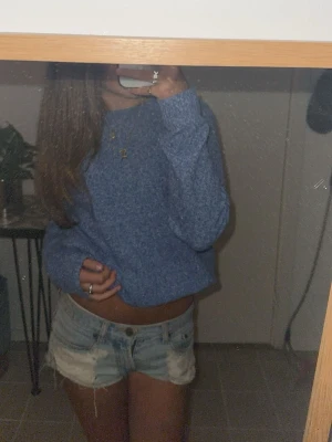  ljusblå jeansshorts - Säljer ett par klassiska ljusblå jeansshorts  med råa kanter och slitna detaljer. Shortsen har fickor, låg midja och en avslappnad passform. Perfekta för somriga dagar. Strl: 36cm i midjemått, 23 cm från toppen och ner. Dem har en slitning/ spricka ihöger ben. Går att sy ihop men själv tycker jag det är snyggt.