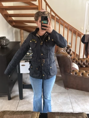 Svart Barbour Jacka - Svart vår/höst jacka från Barbour med guldiga knappar och dragkedja. Jackan är köpt för nått år sen och använd fåtal gånger.