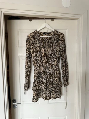 Klänning leopard  - Säljer denna så fina klänning med leopardmönster och volangdetaljer från motel rocks. Jätte fint skick förutom en liten slitning i urringningen (se bild). Storlek M men passar även S och XS💘 