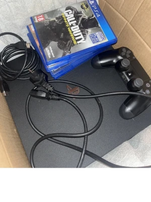 PlayStation 4 Pro  Tb1 med handkontroll  organisation  - Säljer en svart PlayStation 4 Pro från  organisation med en matchande svart DualShock 4-handkontroll. Konsolen är tillverkad i matt plast och har klassisk PS4-design. Medföljer gör strömkabel, HDMI-kabel och flera spel i blå fodral, bland annat Call of Duty och GTA V. Helt ny 