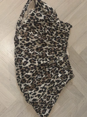 Leopardmönstrad kjol från Gina Tricot - Säljer en kort kjol från Gina Tricot med leopardmönster i beige, brunt och svart. Kjolen har resår i midjan och är gjord i ett lätt och mjukt material som passar perfekt till en trendig och avslappnad stil.
