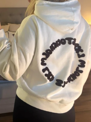 Vit hoodie från LXA med mörkbrunt tryck - Säljer en oversized vit hoodie med stor huva och känguruficka framtill. På ryggen finns en cirkelformad mörkbrun text som är LXA Stockholm. Endast använd några gånger men har en liten difekt vid en arm