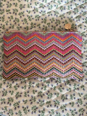 Färgglad oäkta Missoni plånbok med zigzag-mönster - Plånbok f med ikoniskt zigzag-mönster i rosa, lila, gult, grönt och orange. Dragkedja upptill med guldfärgad detalj. Tillverkad i textil med stickad känsla och rektangulär form. Perfekt för dig som gillar färg och mönster.