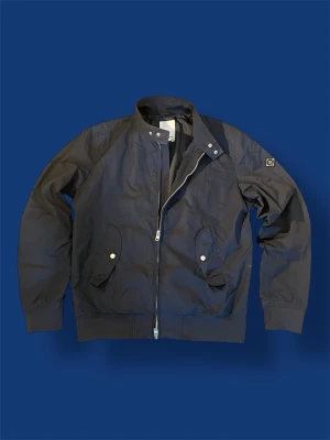 J.Lindeberg fieldjacket L - Nu säljer vi en otroligt fin J.Lindeberg fieldjacket i storlek L, passar M. Jackan är mörkblå och är i ett fantastiskt skick! Tveka inte på att höra av dig vid minsta fundering! Tack!🤩💫