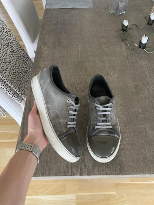 Grå Lanvins - Säljer dessa feta grå lanvin i storlek 41. Skorna är använda och defekter syns på bild👍 riktigt schysst pris för dessa skorna också🔥 Bara o höra av dig vid funderingar👑