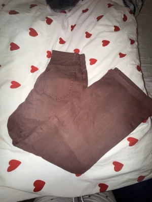 Bruna raka jeans - Säljer ett par bruna jeans med rak passform. Jeansen har hög/normal midja och är tillverkade i ett mjukt denimtyg. Perfekta för dig som vill ha en avslappnad men ändå stilren look.