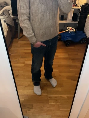 Ljusgrå kabelstickad tröja dobber  - Säljer en ljusgrå kabelstickad tröja från dobber. Den är i nytt skick och kostar egentligen 1100 men säljs för 449 och kan gå ner i pris. Tröjan har rund halsringning, långa ärmar och ribbade muddar vid ärmslut och nederkant. Perfekt för kyliga dagar eller ljusa sommardagar och enkel att matcha med jeans eller andra byxor.