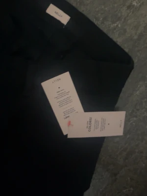 Svarta utsvängda låg midjade jeans från Nelly - Snygga svarta jeans från Nelly med utsvängd passform. Jeansen har trendig zigzag design på bak fickorna. Väldigt långa på mig därför säljer jag. Det är helt nya och etiketten finns kvar på jeansens!