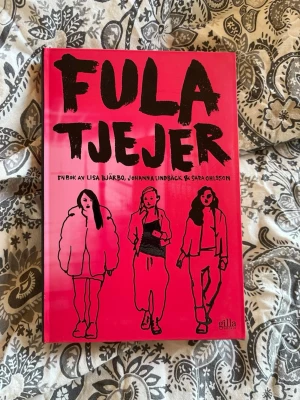 Fula tjejer av Bjärbo, Lindbäck & Ohlsson - En ungdomsroman med starkt rosa hård pärm och svart text, skriven av Lisa Bjärbo, Johanna Lindbäck och Sara Ohlsson. Omslaget har illustrationer av tre tjejer i olika kläder. Perfekt för dig som gillar samtida berättelser om vänskap och identitet.