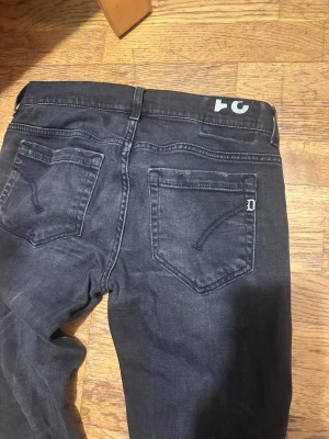 Svarta jeans från Dondup - Snygga svarta jeans från Dondup med klassisk femficksdesign och diskret D-detalj på bakfickan. Jeansen har en rak passform och är tillverkade i mjukt denimtyg med lätt tvättad look. Perfekt för dig som gillar stilrena och moderna jeans. Storleken är w31, för korta för mig.