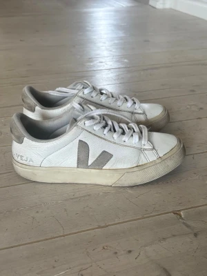 Vita Veja sneakers med grå detaljer - Fina stilrena  vita sneakers från Veja med gråa detaljer och klassisk V-logga på sidan. 
