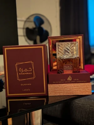 Lattafa Khamrah Dukhan Eau de Parfum 100ml - Säljer Lattafa Khamrah Dukhan (100 ml), den senaste och mörkaste flankern i serien. Flaskan är endast testsprayad. Detta är perfekta doften för dig som vill ha Khamrah-seriens lyxiga sötma, men med en mörkare twist av tobak, rökelse och kryddor. Flaskan har stått och mognat i en månad, vilket gjort doften mycket rundare och fylligare än en nyöppnad flaska. Mängd: 99/100 ml.