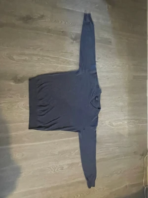 Mörkblå V-ringad tröja Signal - Mörkblå långärmad tröja från Signal med V-ringning och ribbade muddar vid hals, ärmslut och nederkant. Enkel och stilren design som passar perfekt till jeans eller chinos. Skön och mjuk känsla, perfekt för lager-på-lager.