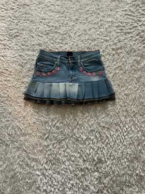Jeanskjol med blommor - En Lågmidjad jeanskjol omsydd från ett par jeans. 💕  Midjemått tvärsöver- 35 cm (stretchig) Längd - 29cm