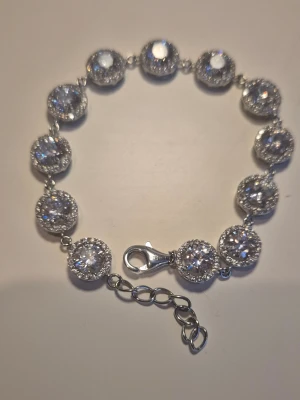 Silver armband med glittrande pärlor Sterling  - Ett snyggt armband i silverfärg med runda, glittrande pärlor i rad. Varje pärla är omgiven av små gnistrande stenar som ger extra bling. Armbandet har ett justerbart spänne. Sterling 