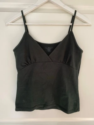 Grönt linne från Brandy Melville - Linne/babydoll topp från Brandy Melville. Bild 3 visar färgen i solljus då de första två bilderna såg lite mörka ut! Använd typ 1 gång så väldigt bra skick 💗Jag skulle gissa på att nypriset ligger runt 200 kr 