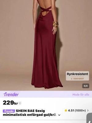 Vinröd långklänning från SHEIN - Vinröd långklänning från SHEIN med minimalistisk design. Klänningen har öppen rygg med snygga banddetaljer och v-ringad front. Tillverkad i ett glansigt material som ger en elegant look. Perfekt för dig som vill sticka ut.