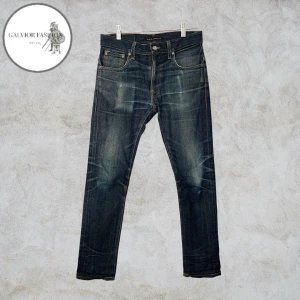 Nudie Jeans Taped Ted Dry Selvedge - Nudie Jeans Taped Ted Dry Selvedge jeans. Otroligt snygga jeans som har utvecklat en vacker patina, dessa typer av jeans är kända just för att utveckla snygga, personliga fades med tydlig karaktär.  Skick 7.5/10 inga märkvärdiga defekter, har mycket kvar att ge. Storlek W30/L30 men passar även W29. Hör av dig för mått!                                                                  ~ Liknande säljs för 1000–3000 kr | mitt pris 1 599 kr. Alla följare får rabatt, så följ!