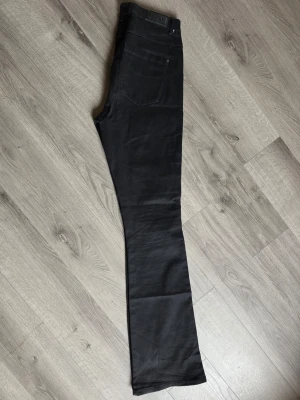 Svarta bootcut jeans Only - Säljer ett par svarta bootcut jeans från ONLY blush med klassisk femficksdesign och hög midja. Jeansen har en snygg passform som framhäver benen och är tillverkade i ett stretchigt material för extra komfort. Perfekta för dig som gillar stilrena och trendiga jeans.