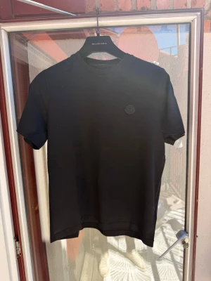 Svart Moncler t-shirt med logga - Svart t-shirt från Moncler med diskret logga på bröstet och stor Moncler-text på ryggen. Köpt för nåt år sen, aldrig använd. Nypris 3500kr +