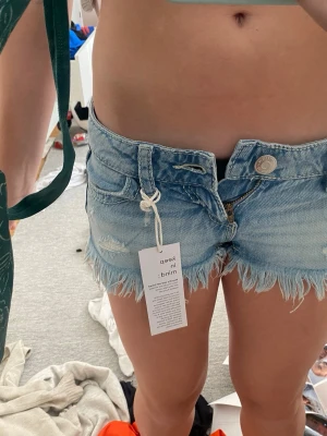 Ljusblå lågmidjade jeansshorts - Säljer ett par super lågmidjade jenashorts perfekt till sommaren i storleken xxs!! Är helt nya så har aldrig använt dem! Pris kan diskuteras