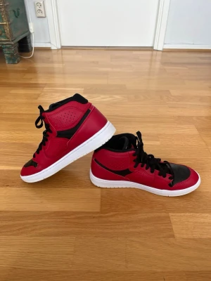 Jordan Mid sneakers storlek 41 – mycket gott skick - Säljer ett par riktigt snygga Jordan Mid sneakers i röd/svart färgkombination med vit sula. Skorna är i mycket gott skick och har endast använts sparsamt. Bekväma både till vardag och streetwear och passar lika bra till jeans som till mjukis eller shorts. Storlek 41. Skorna är rena och fina med normalt mindre användningsslitage.