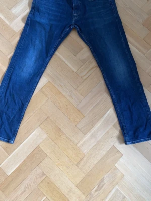 Blå raka jeans från Replay - Säljer ett par snygga Replay Rocco Selvedge jeans i storlek W31/L30. Mörkblå tvätt med clean look och fina detaljer. Slim/tapered passform som sitter riktigt bra med boots eller polos/tröjor.  Bra skick utan större slitningar. Replay Sustainable Lab modell. Pris: 499 kr (kan diskuteras vid snabb affär)