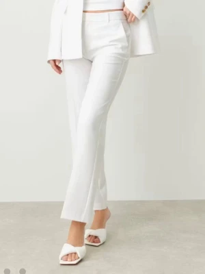 Vita kostymbyxor från Gina Tricot  - Säljer ett par stilrena vita kostymbyxor från Gina tricot Byxorna har raka ben, pressveck och normal midja. De är tillverkade i ett lätt tyg som ger en snygg och fräsch look. Perfekta att matcha med kavaj eller crop top för en trendig outfit.