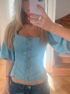 Jeans topp - Trendig ljusblå topp i denim med puffärmar och knappar framtill. Funkar super fint för sommaren! ❤️