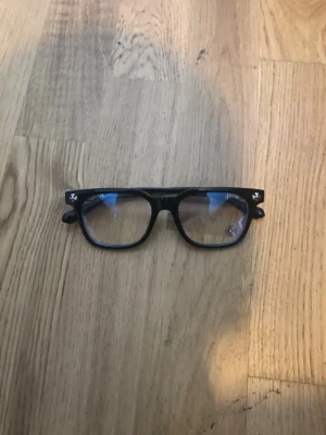 Svarta Chrome Hearts Glasögon - Snygga svarta chromehearts med bluelight glas och dekorativ blomdetalj på bågen. Rektangulär form som ger en cool retrovibe. Perfekta för dig som vill sticka ut lite extra.