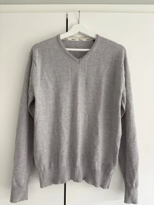 Ljusgrå stickad tröja V-ringad - Klassisk stenström pullover i färgen ljusgrå. Perfekt att ha över en vit skjorta till sommaren.   Använd fåtal gånger men krympt lite i tvätten. Passar som en M  