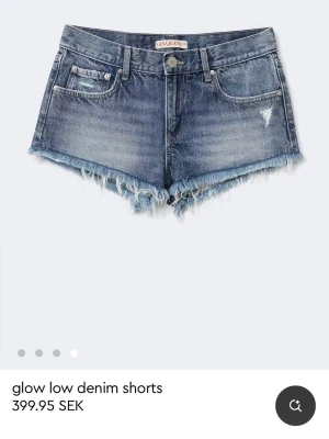 Lågmidjade denimshorts från Gina Jeans - Snygga blå denimshorts från Gina Jeans med låg midja, fransig rå kant och slitna detaljer. Helt nya med prislapp kvar. Passade tyvärr inte mig och kan ej lämna tillbaka då det gått mer än en månad.🌺🥰