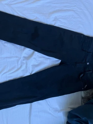 Svarta jeans från Replay - Snygga svarta jeans från Replay med klassisk femficksmodell och raka ben. Jeansen har en stilren look och är tillverkade i stretchigt denimtyg för extra komfort. Perfekta för dig som gillar en enkel och tidlös stil.