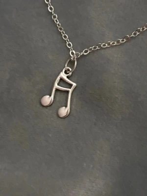 Halsband Not Smycke Silver imitation Noter - Så fint halsband med en not. Trädd på kedja i silverimitation som är justerbar 40-45 cm. Berlocken är ca 2,5x 1,1 cm. 