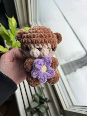 Virkad ljusbrun utter🤎💜 - Supersöt virkad mini-utter i ljusbrun som håller i en liten lila blomma.🦦💜