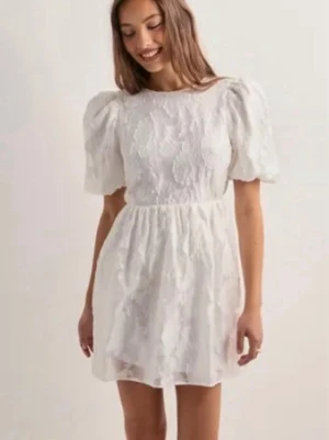 Vit kortklänning med puffärmar - Säljer en vit kortklänning från Gina tricot. Den har puffiga ärmar och blommigt mönster vilket ger en somrig känsla, perfekt till student eller sommarfest!