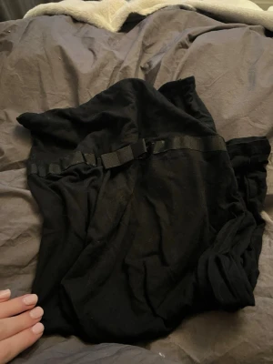 Svart klänning med rosett - Svart klänning från Gina tricot utan band. Klänningen har en rosett och har ett otroligt mjukt tyg. Klänningen går över låren men är inte jättelång. Passar perfekt till sommaren och perfekt till stranden. 