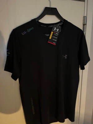 Under Armour  - Träningströja, sitter tajt o bra. Perfekt till den som tränar mycket. Storlek M passar S också. Helt ny aldrig använd med prislapp på. Köpt från vinted från en kvinna som påstod att den va äkta så litar på henne. Reflex också!