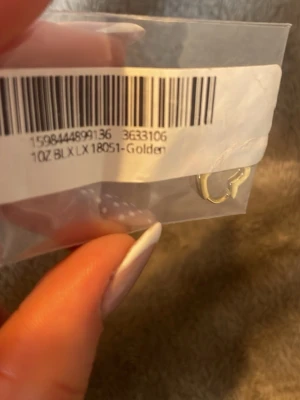 Guld hjärtformade örhängen ( RIKTIGT GULD) - Säljer ett par små örhängen i riktig guld, formade som hjärtan. De är stilrena och passar perfekt för dig som gillar minimalistiska accessoarer med en touch av romantik. Örhängena är tillverkade i metall och har en enkel klickstängning.
