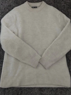 Stickad tröja från Zara  - Jätte snygg stickad tröja från Zara som är vit och jätte skön, de är storlek S men skulle verkligen säga att den är stor i storleken så känns som m 