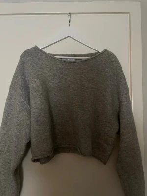 Grå cropped stickad tröja Bershka - Säljer du en grå cropped stickad tröja från Bershka. Tröjan har långa ärmar, rund halsringning och är gjord i mjukt stickat material. Perfekt för lager på lager och en chill look.