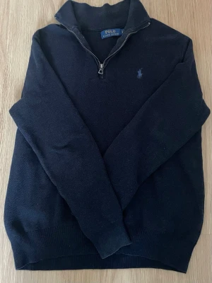 Mörkblå half zip tröja från Polo Ralph Lauren - Säljer en Ralph Lauren Half Zip tröja, den är marinblå och är i ganska bra skick😃 Hör av er om ni har frågor!