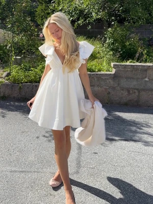 Studentklänning  - Köpte inför min student 2025 så den är enbart använd en gång och inga fläckar eller defekter. Den har resår vid axlarna samt en dragkedja i ryggen och en superfin rosett som man knyter själv. Jag är 165 lång och den sitter precis ovanför knäna på mig. Hör av er vid frågor eller liknande!🥰