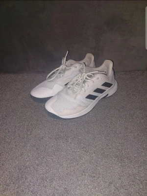 Vita Adidas Tennis/padel skor - Är i mycket bra skick använda ett fåtal gånger endast i padel men funkar lika bra på tennis. Torsion system för bättre stabilitet i mitten på foten och förebygger stukningar.