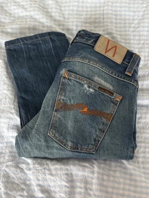 Slitna Grim Tim jeans från Nudie Jeans 28/31 - Säljer mina unika nudie jeans storlek 28/31. Sjukt snygga och unika med patchwork och slitningar. Perfekta för en avslappnad och trendig stil. Pris går att diskutera. 