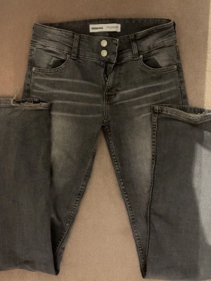 Gråa flaire jeans från Bershka - Snygga gråa skinny jeans från Bershka med medel midja och dubbla knappar. 