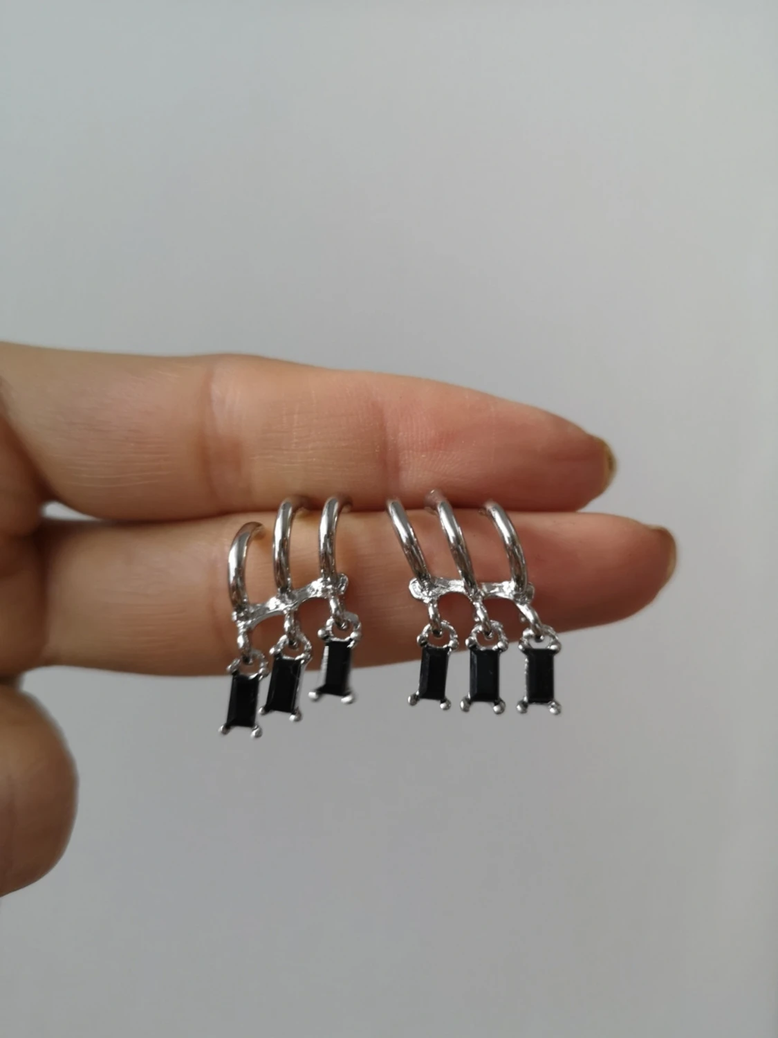 Silvriga örhängen med svarta stenar